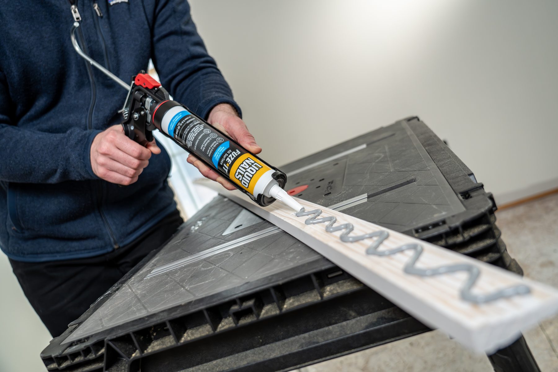 Liquid Nails Fuze*It cartridge in a caulk gun on a job site saw horse